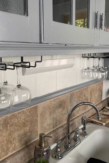 a reviewer's wine glass rack under kitchen cabinets