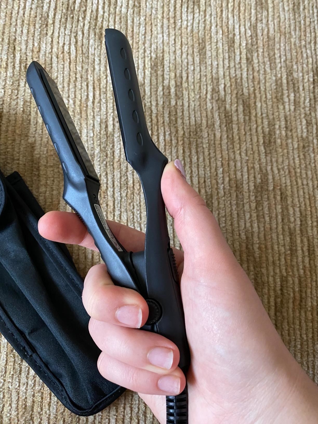 reviewer hand holding straightener