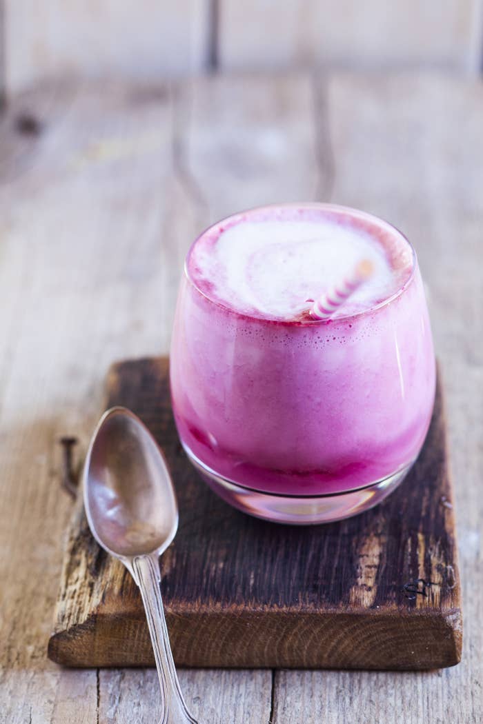 A pink Hibiscus Rose latte in a glass