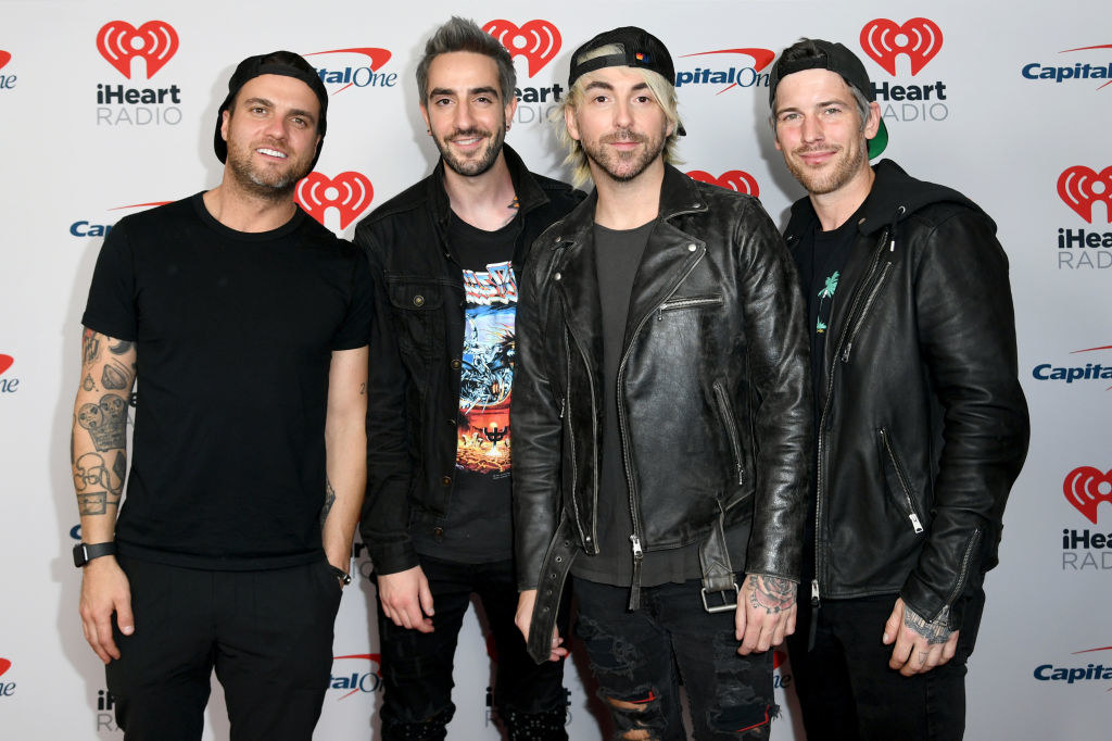 All Time Low members Alex Gaskarth, Jack Barakat, Zack Merrick, and Rian Dawson pose at an iHeartRadio event