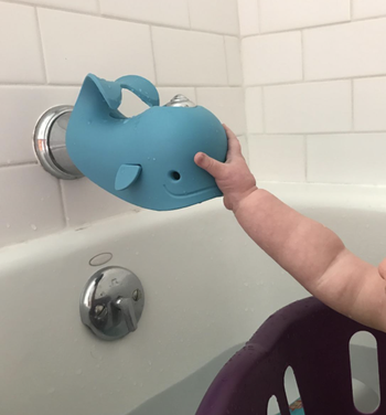 reviewer image of toddler touching faucet cover