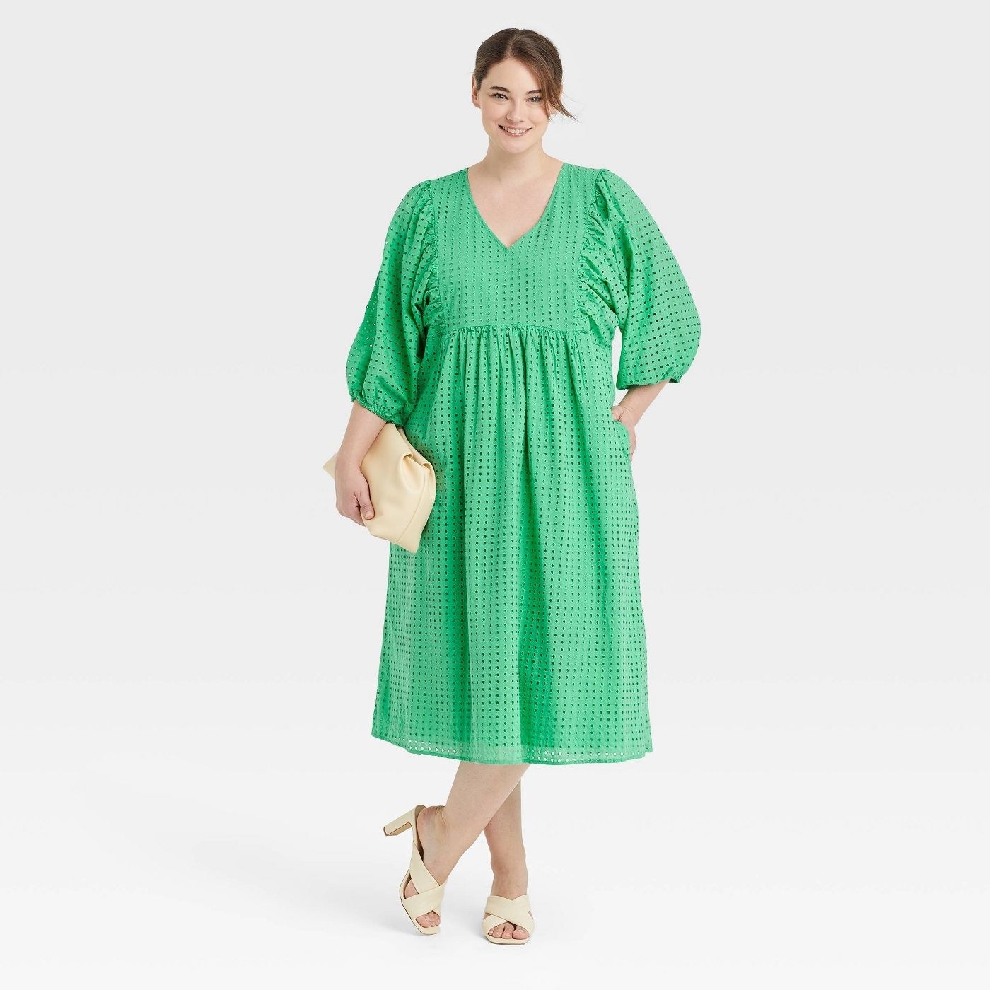 Model wearing green dress with white shoes