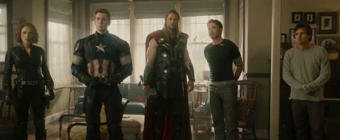 The 6 Avengers standing in a living room