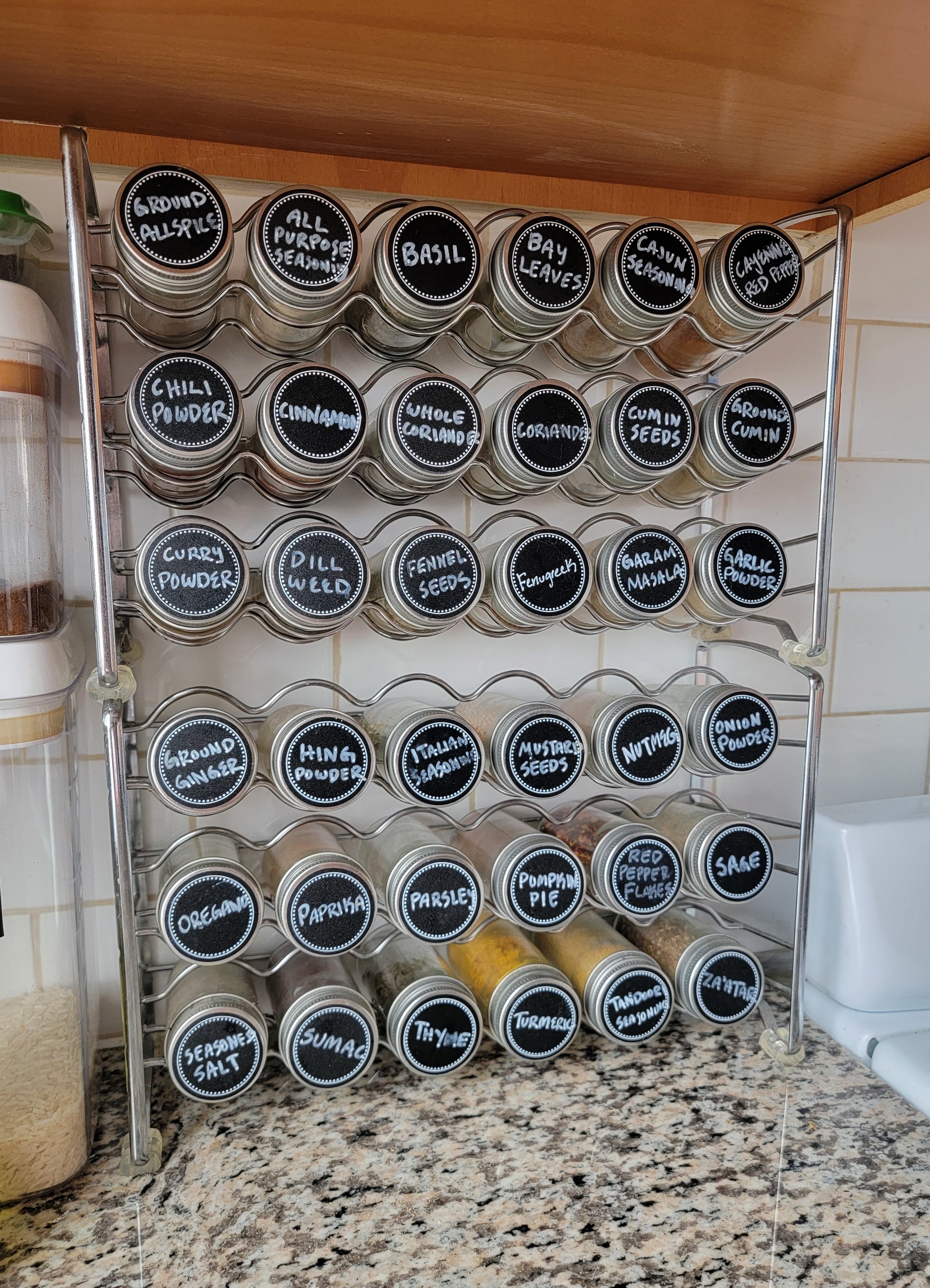spice rack with labels for each spice on the lids facing forward