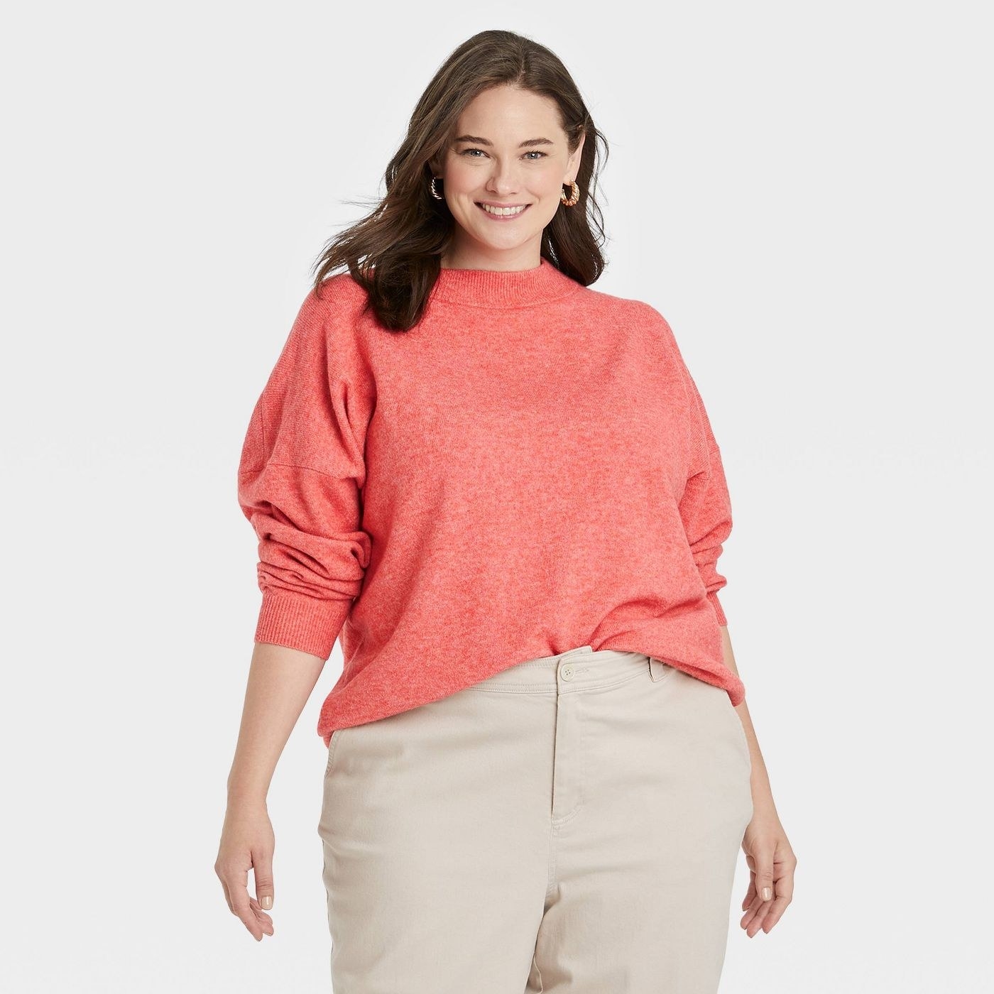 Model wearing the coral slouchy mock turtleneck sweater