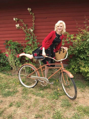 Reviewer photo of them wearing a black dress with red florals on them and a red cardigan