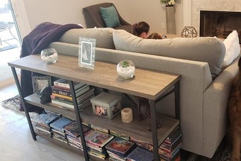 reviewer image of the brown three-shelf skinny table behind a couch
