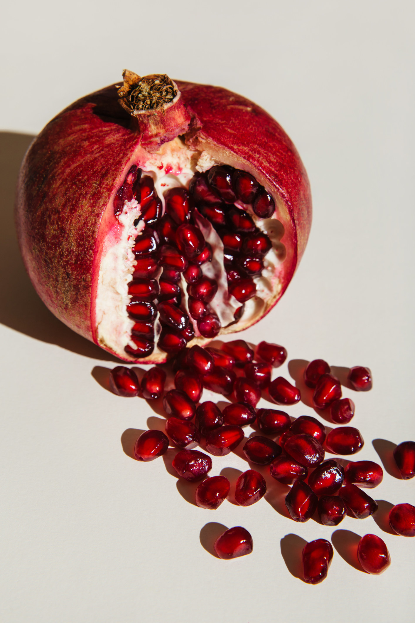 Cut pomegranate on a white background. Menstruation concept. Symbol of vagina. Gynecology, female intimate health