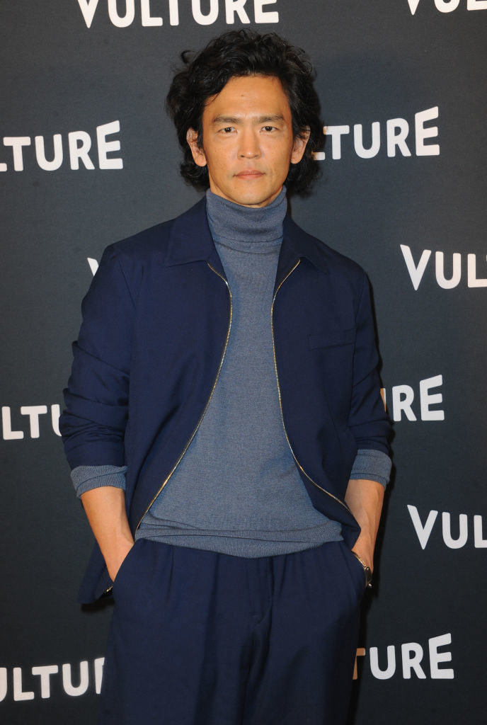 dressed in a sleek turtleneck and matching jacket and pants, the curly-haired actor, poses with his hands in his pockets