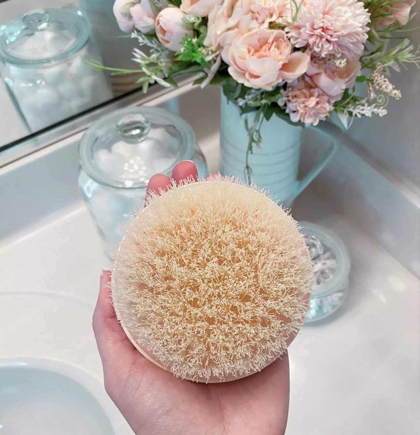 Someone holding the circular brush in the palm of their hand