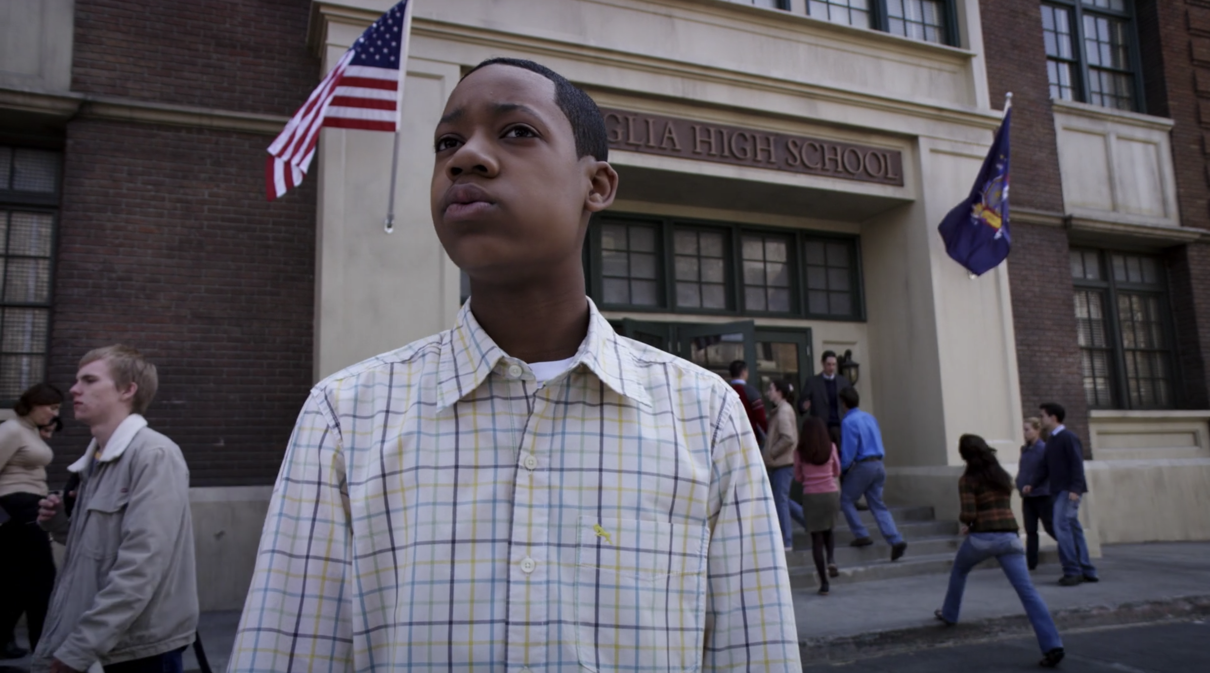 Tyler James Williams stands outside a school