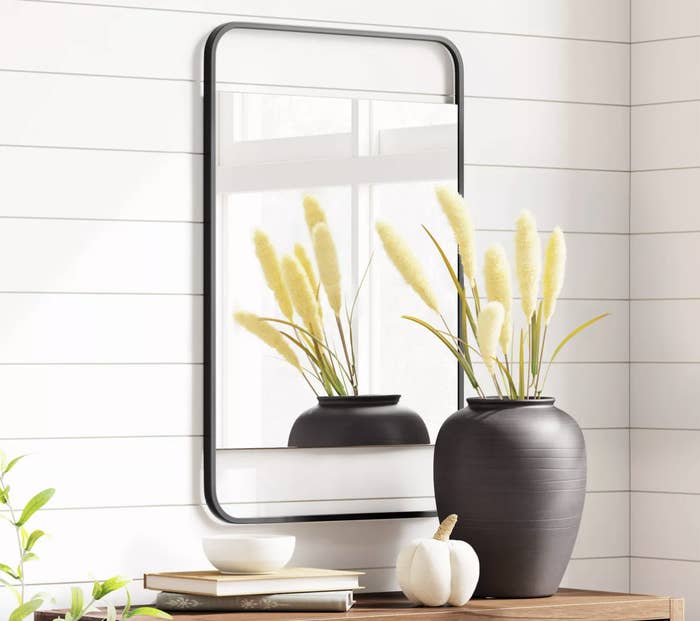 a rounded mirror with a black beveled edge