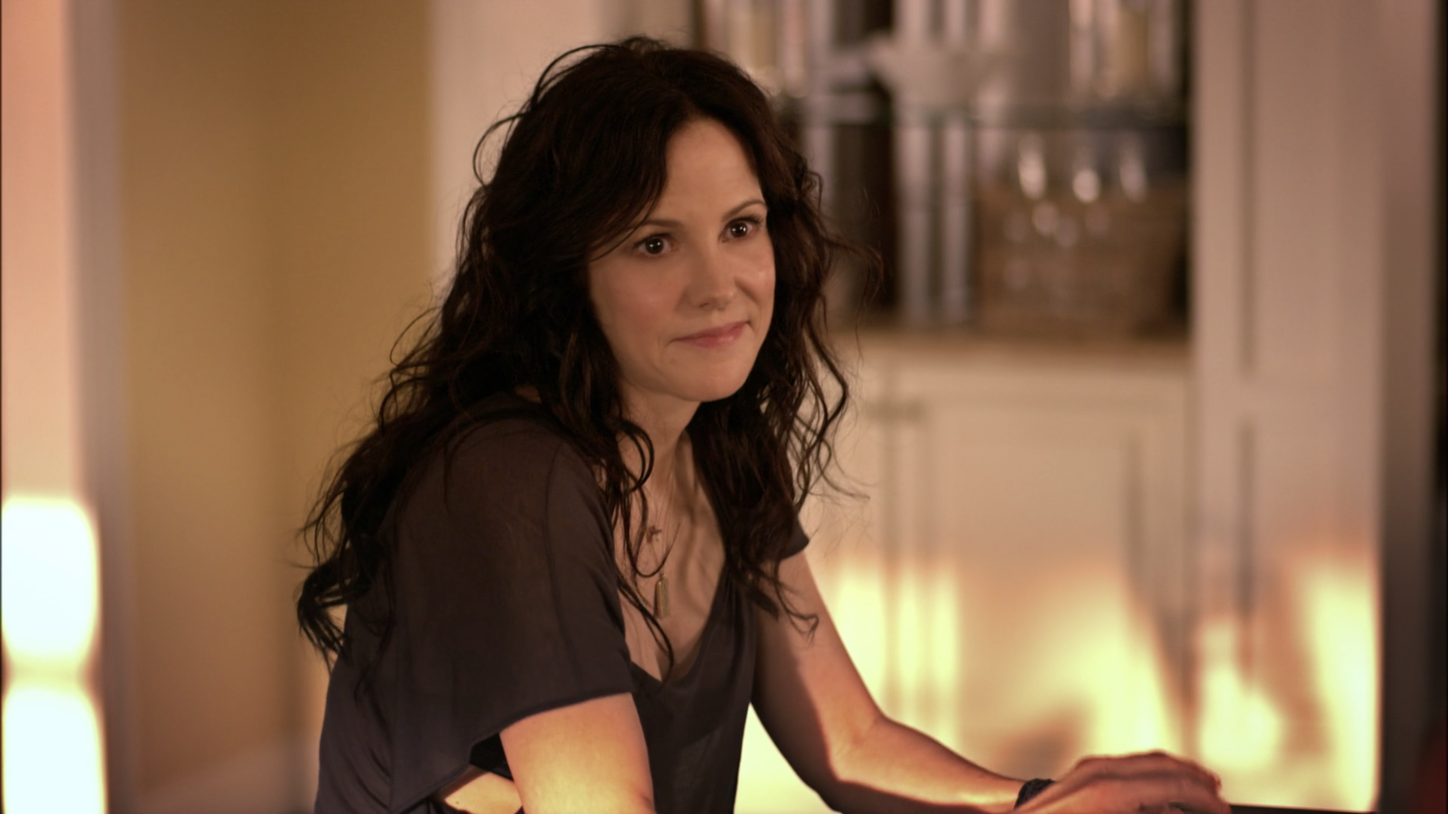 Mary-Louise Parker sits at a counter