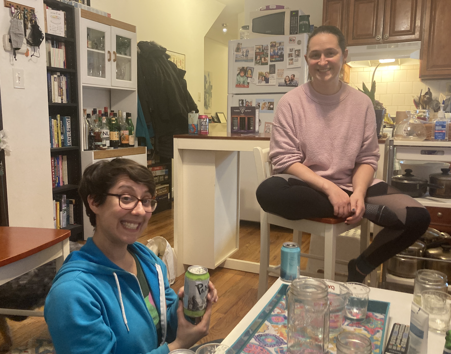 Two friends in an apartment sit down to have some fake booze