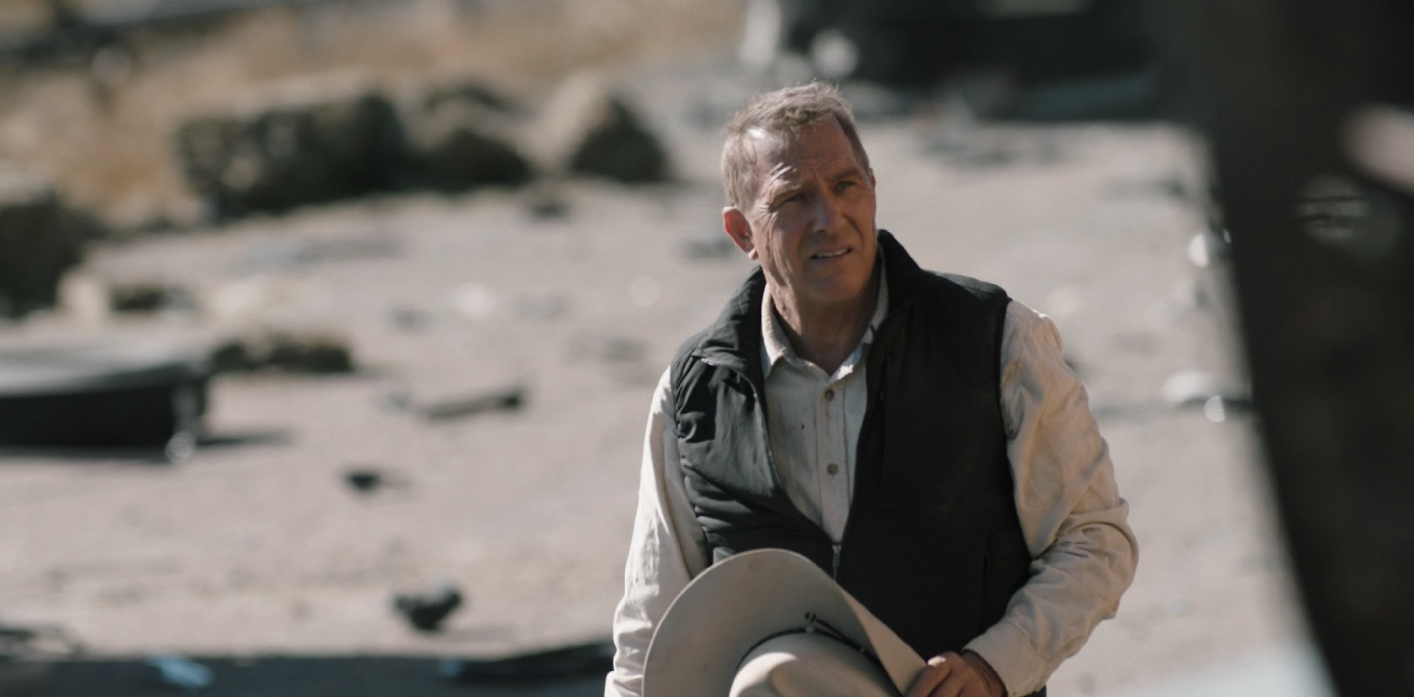 Kevin Costner holds a cowboy hat