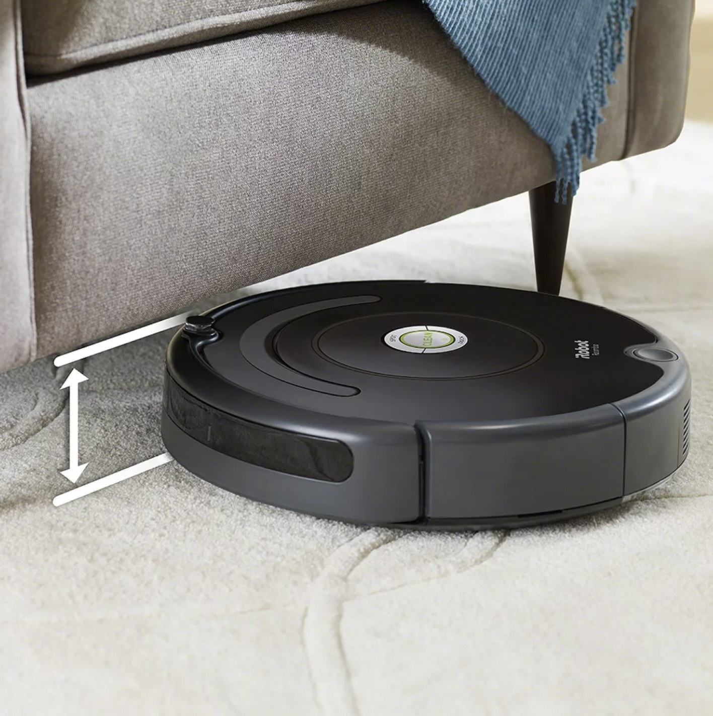 The robot vacuum on carpet navigating under the couch