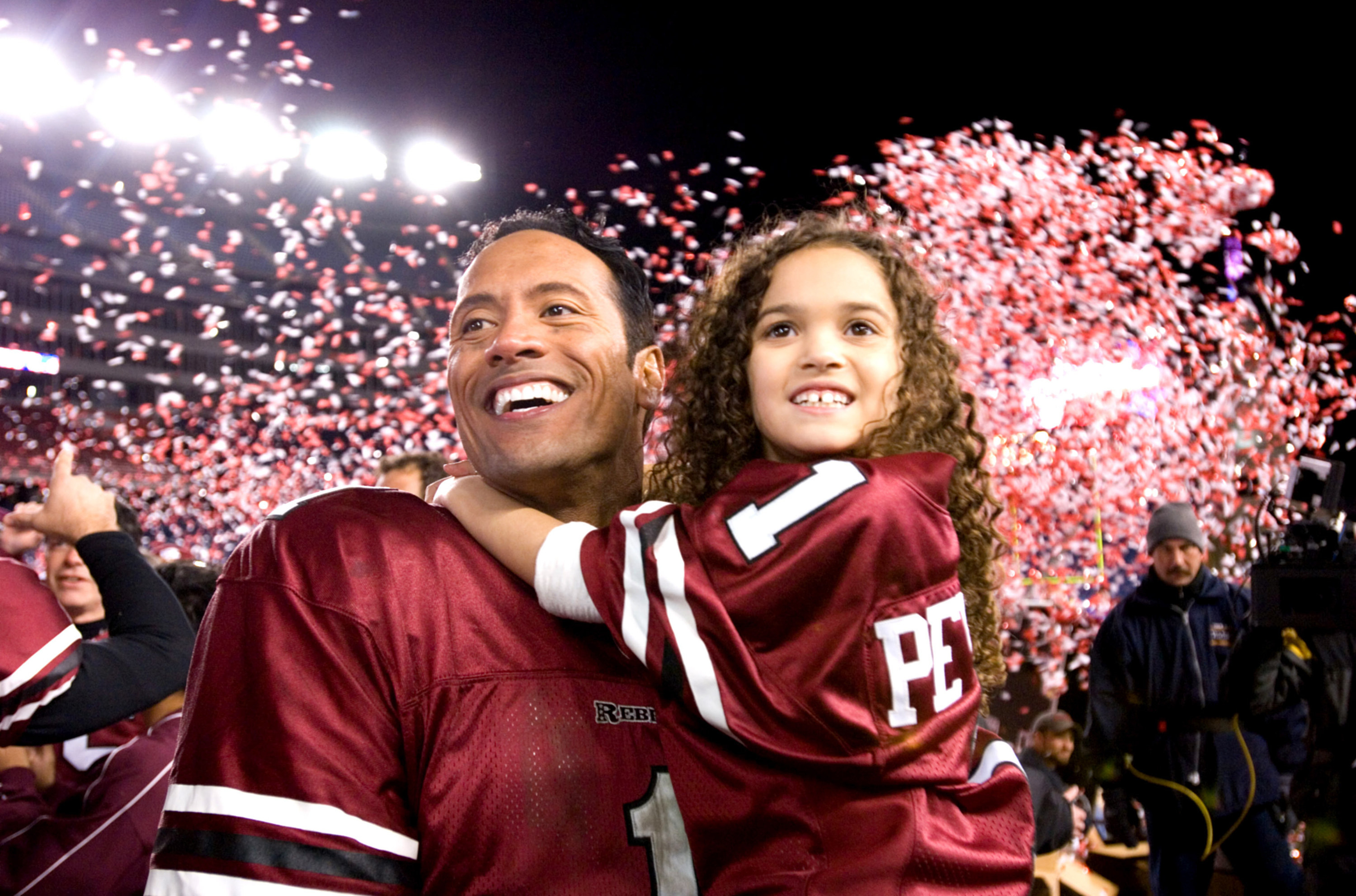 Dwayne Johnson and Madison Pettis celebrating on the field in &quot;The Game Plan&quot;