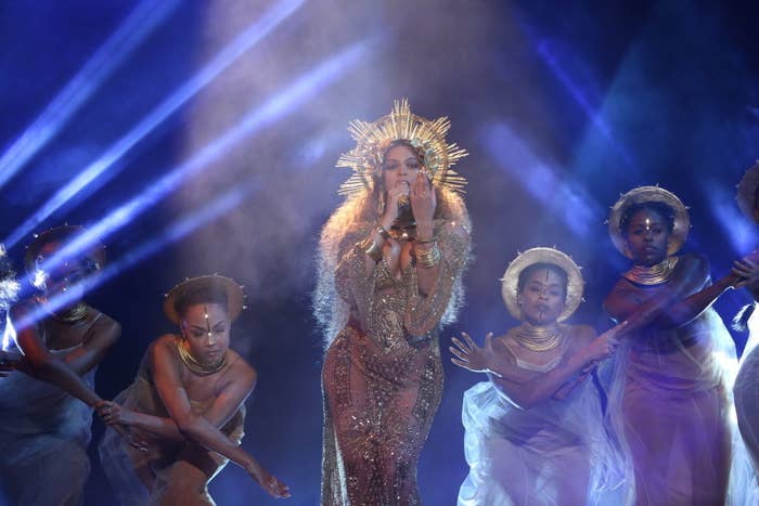 Beyonce in gold surrounded by dancers
