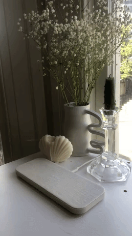 A gif of Amanda placing an AirPod case on the station