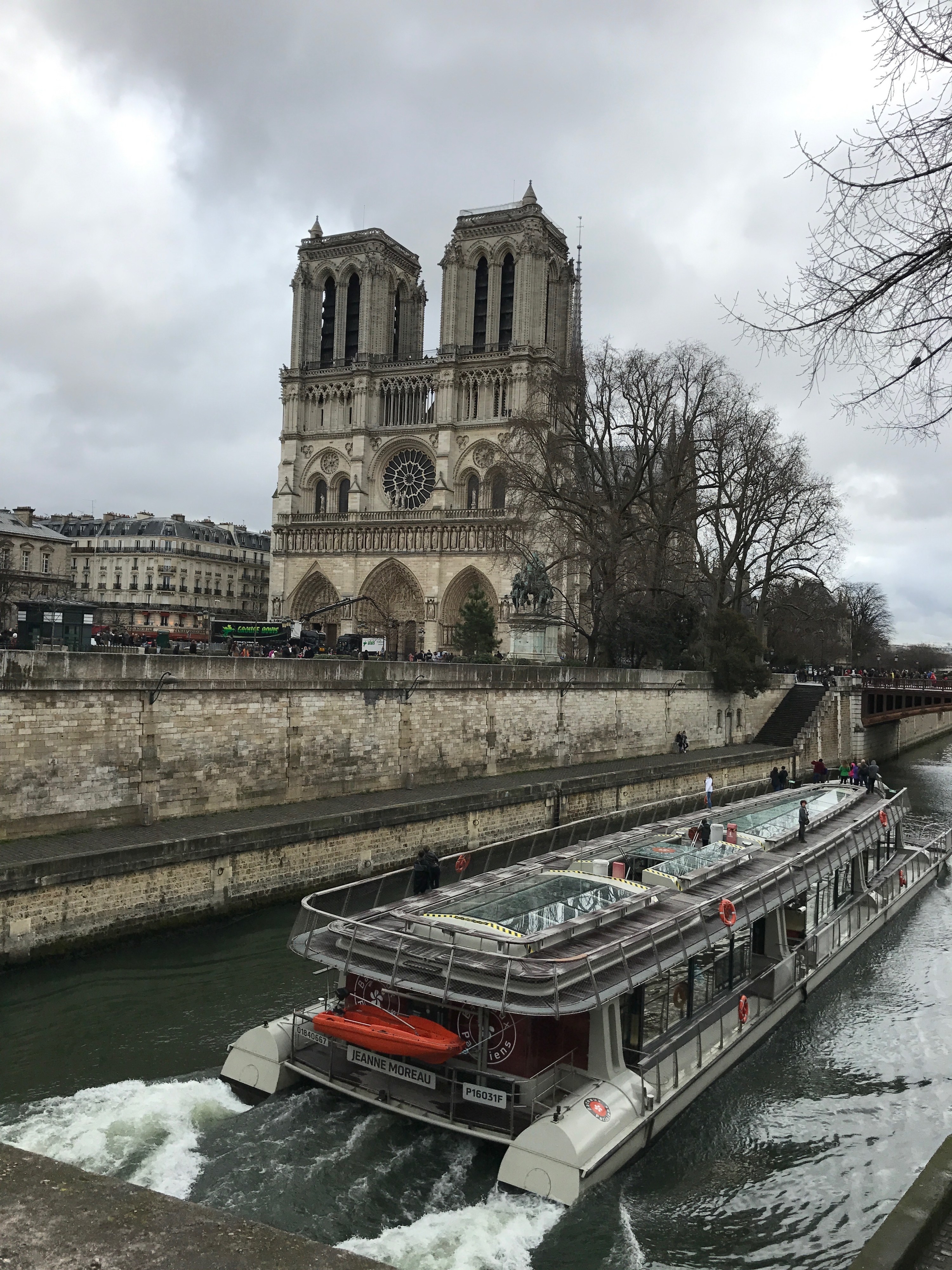 The exterior of Notre Dame with a riverboat passing by