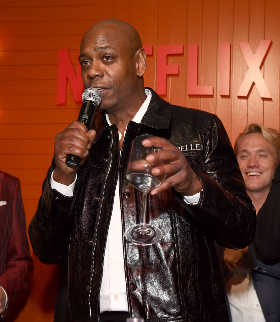 Chappelle with a mic and wine glass in hand