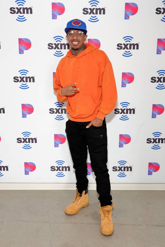 Nick Cannon in an orange sweater at an SXM event