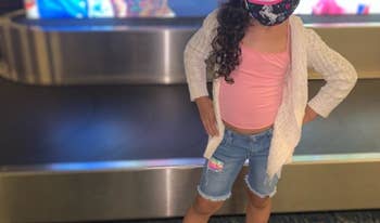 reviewer's photo of their child wearing the iridescent pink sneaker