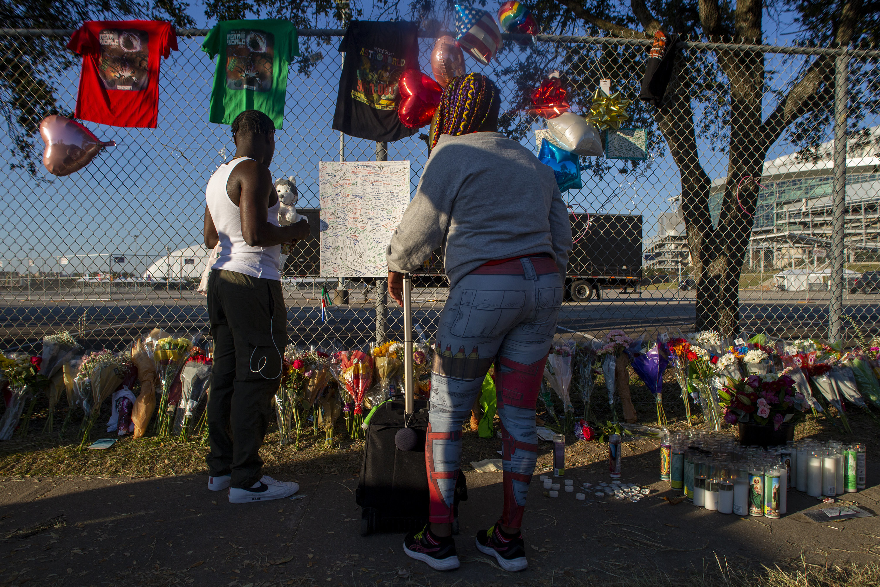 People attend a makeshift memorial on November 7, 2021, at the NRG Park grounds where eight people died in a crowd surge at the Astroworld Festival in Houston