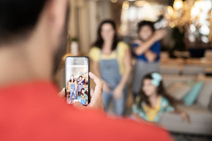 A parent films a video of the family dancing at home