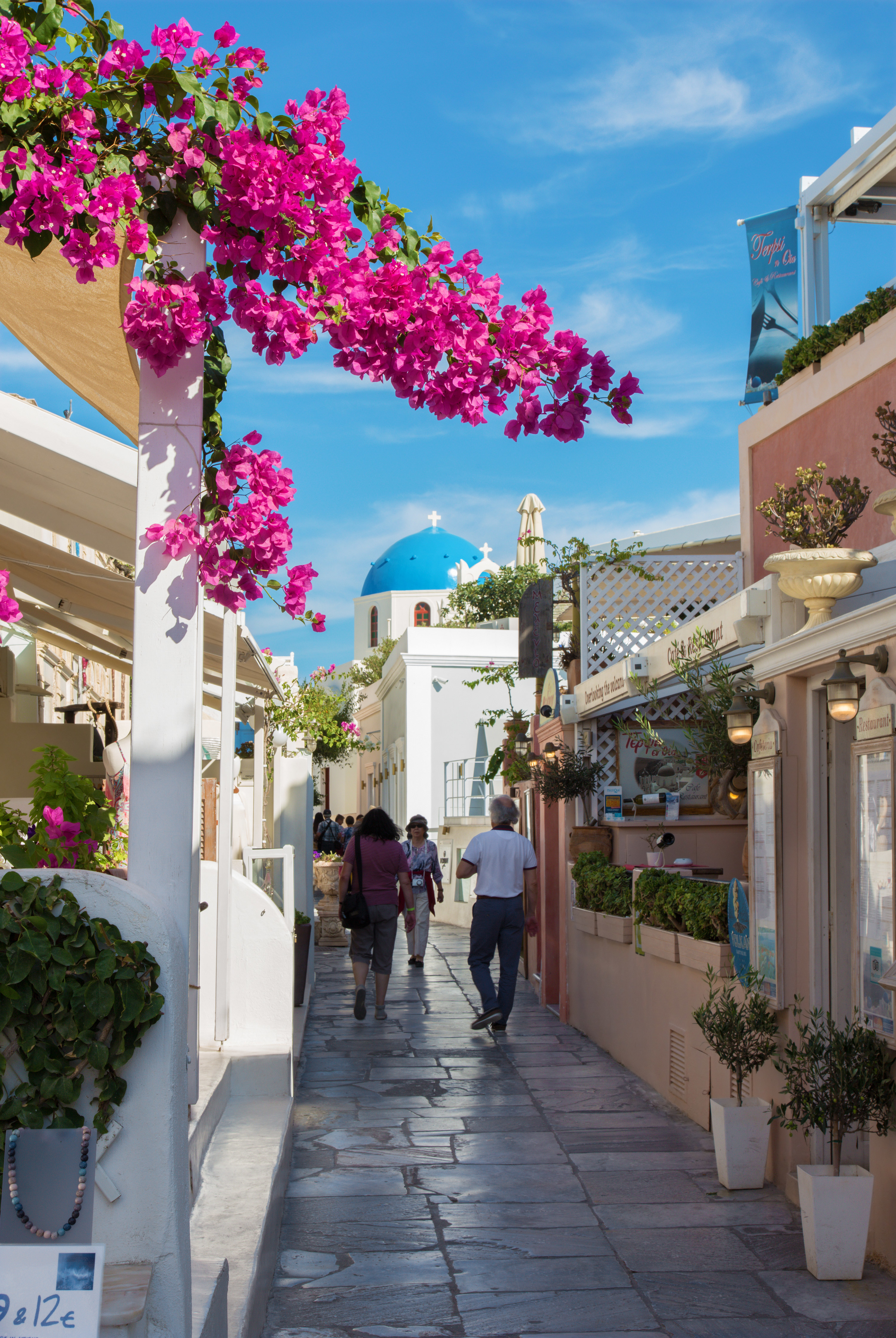 The street of Oia with the souvenirs shops and restaurants and number of peoples.
