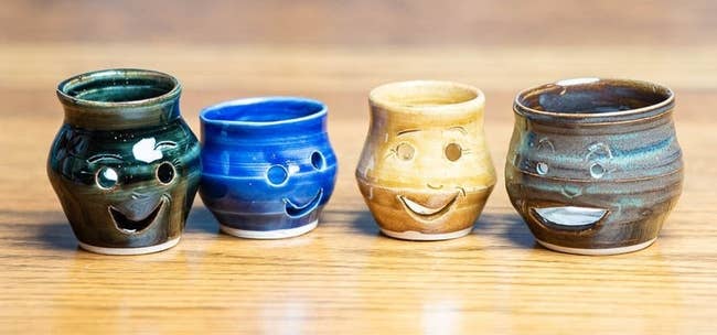 four smiley face ceramic egg separators