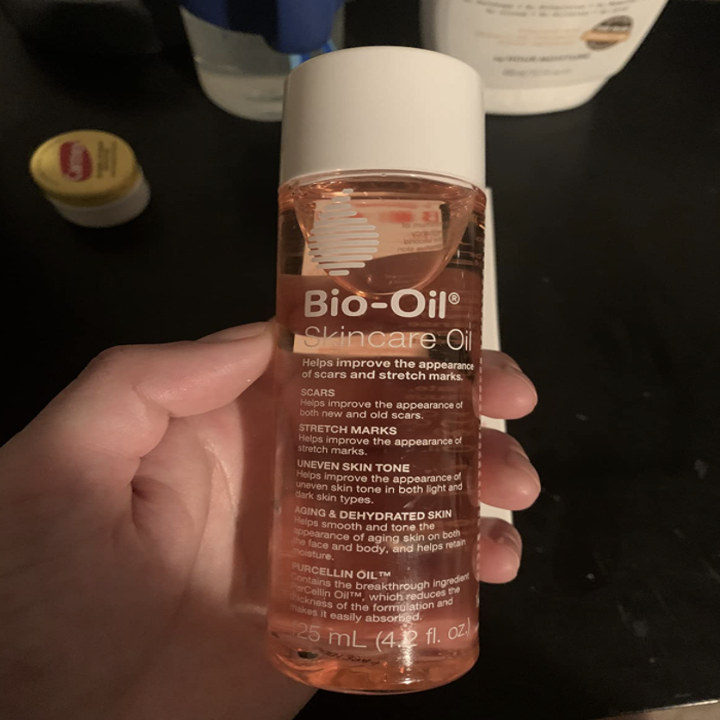 reviewer holding bottle of bio oil