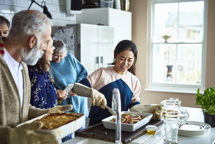 Extended family members prepare a meal together in the kitchen