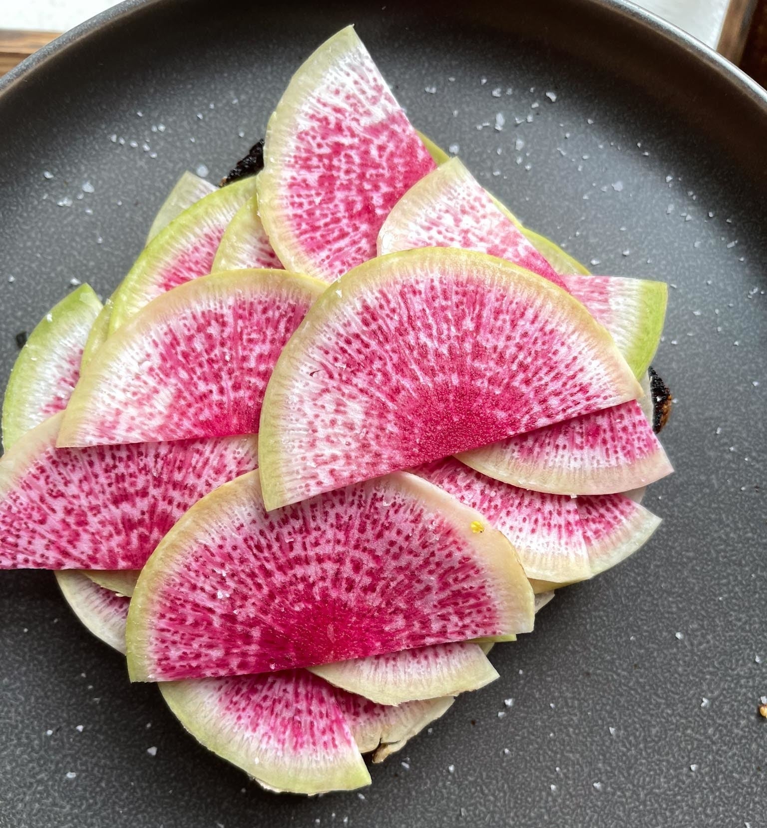 Thinly-sliced watermelon radishes on a piece of toast