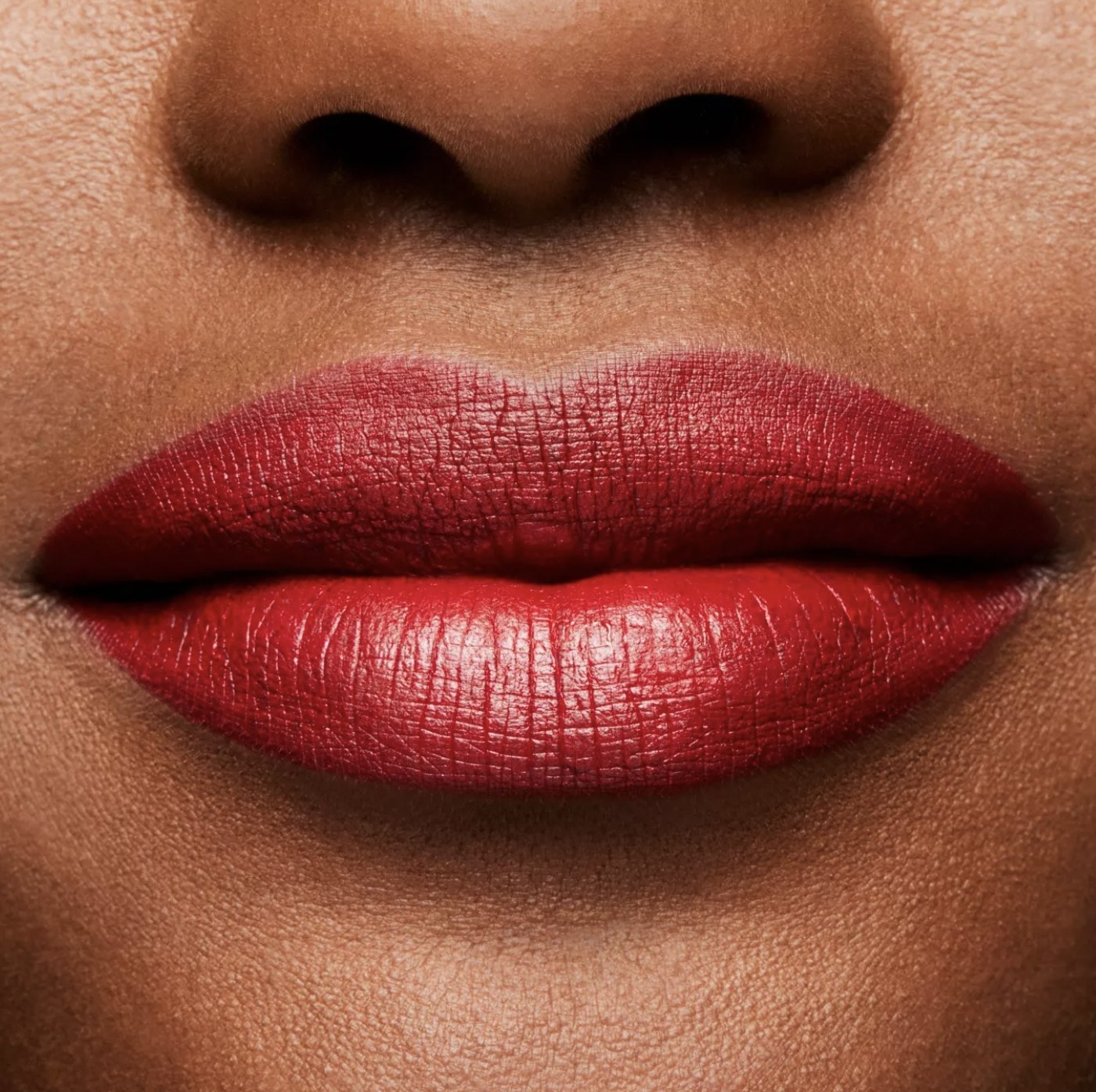 Darker skinned model in close-up showing the matte red lipstick