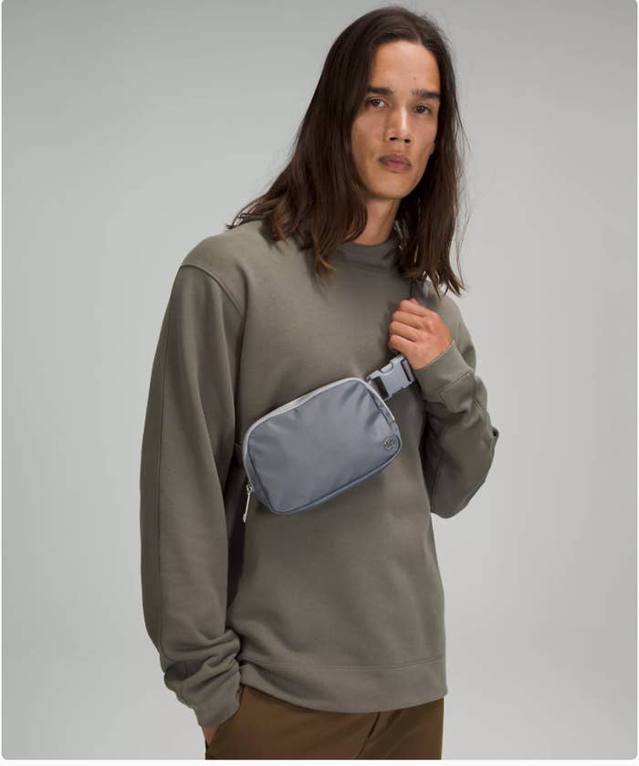 A person wearing the belt bag against a plain background