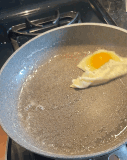 Author swirling fried egg in nonstick pan