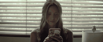 GIF woman on phone smiling