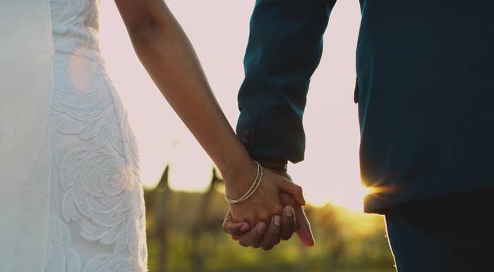 A newlywed couple hold hands outside on their wedding day