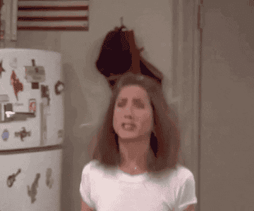 a gif of rachel green from friends jumping up and down and shouting oh my god