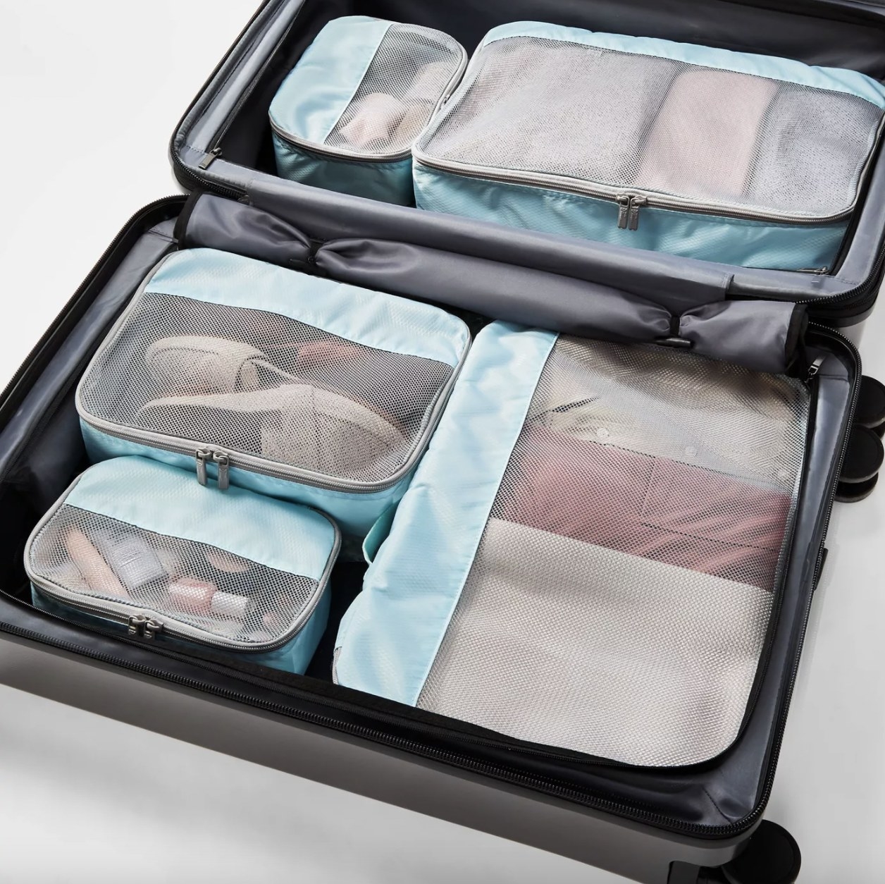 Five packing cubes in a suitcase