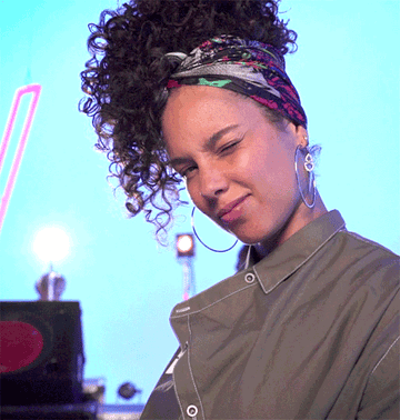 Alicia Keys looking gorgeous with no makeup smiling and winking