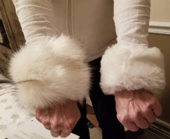 reviewer wearing two different faux fur wrist cuffs