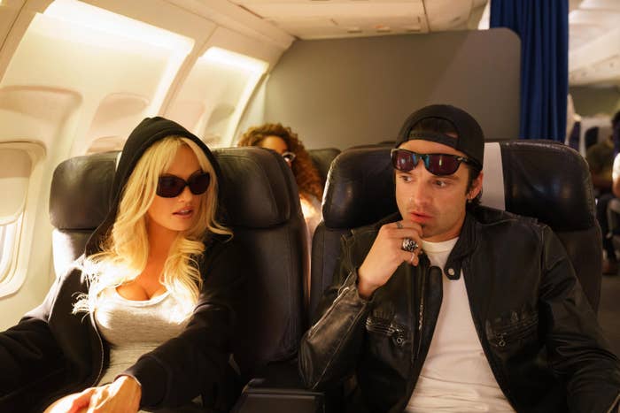 The actors as Pam and Tommy sitting in an airplane