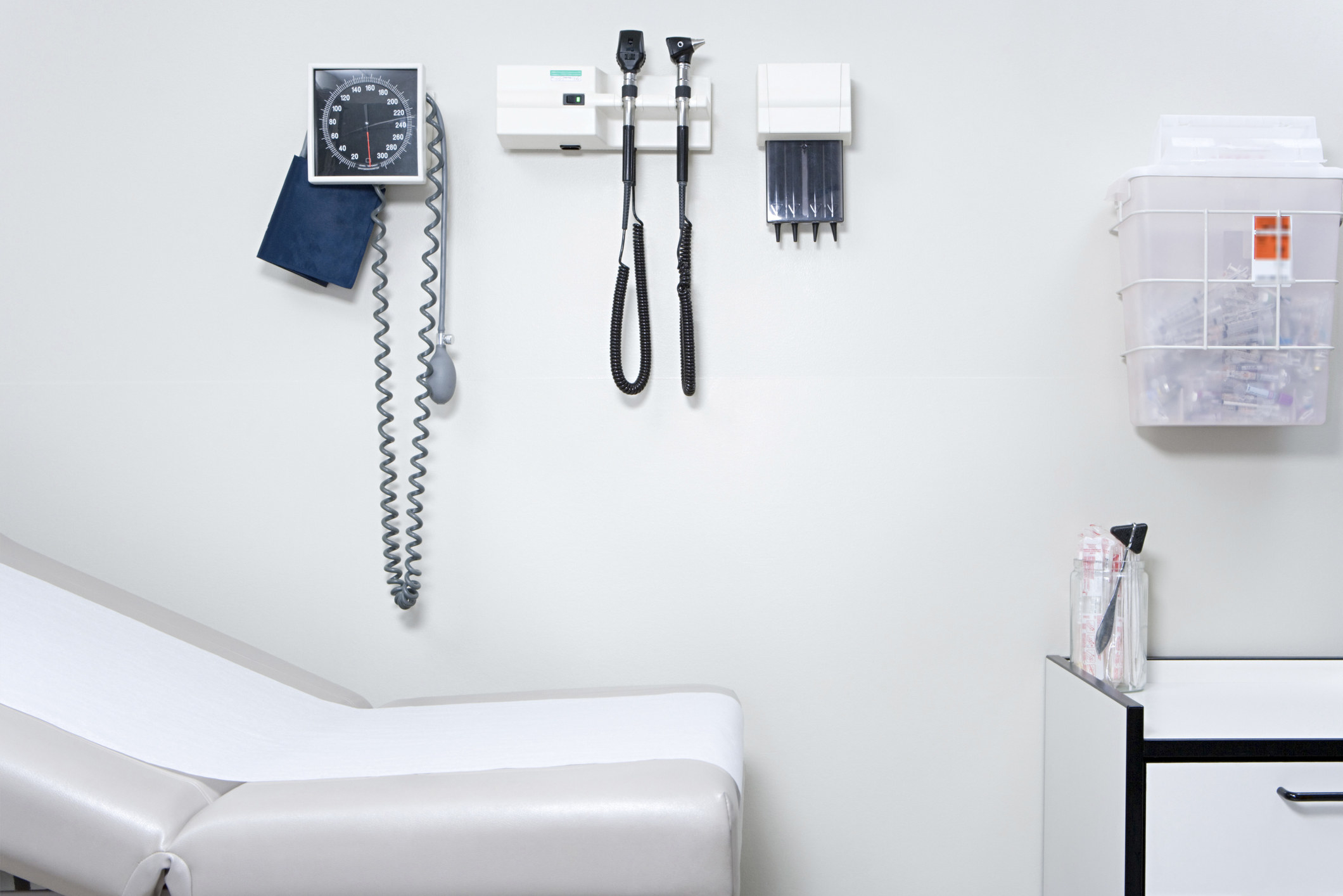 A stock image of the inside of a doctor&#x27;s office with tools like a blood pressure machine attached to the walls