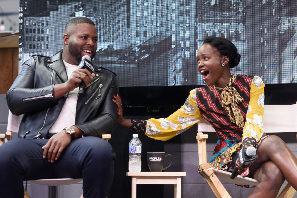 Lupita nyong&#x27;o puts her arm on winston duke during an interview