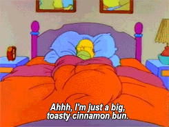 A gif from the simpsons of Homer curled up in bed saying &quot;Ahhh, I&#x27;m just a big, toasty cinnamon bun.&quot;