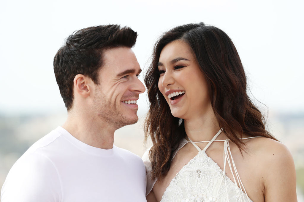richard madden and gemma chan smiling at each other during an event for eternals