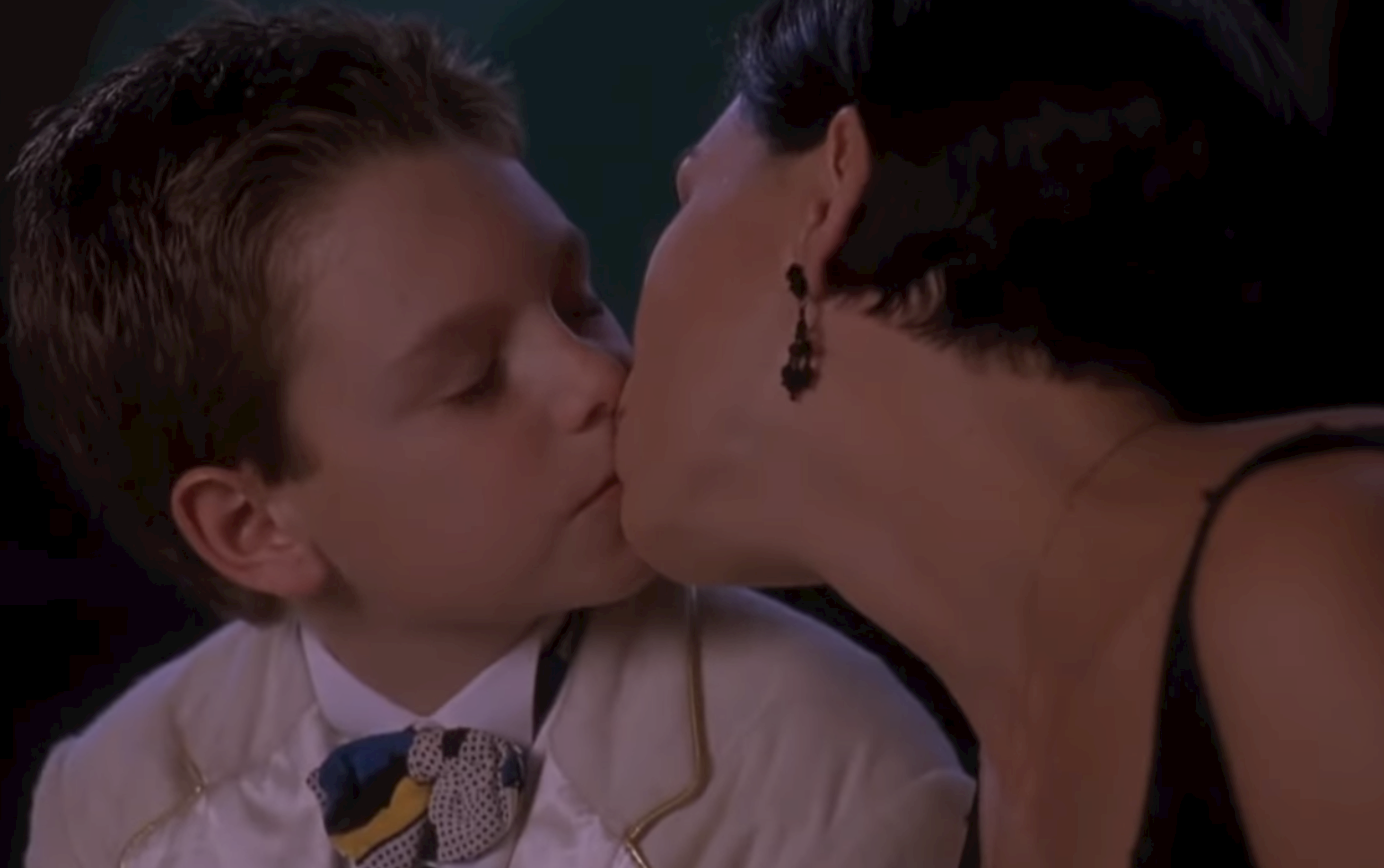 A little boy kissing a grown woman