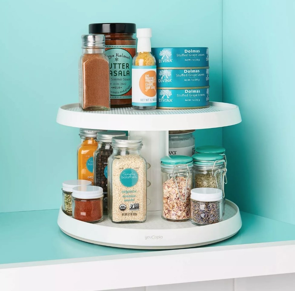 A two-tier turntable in a pantry with spices atop